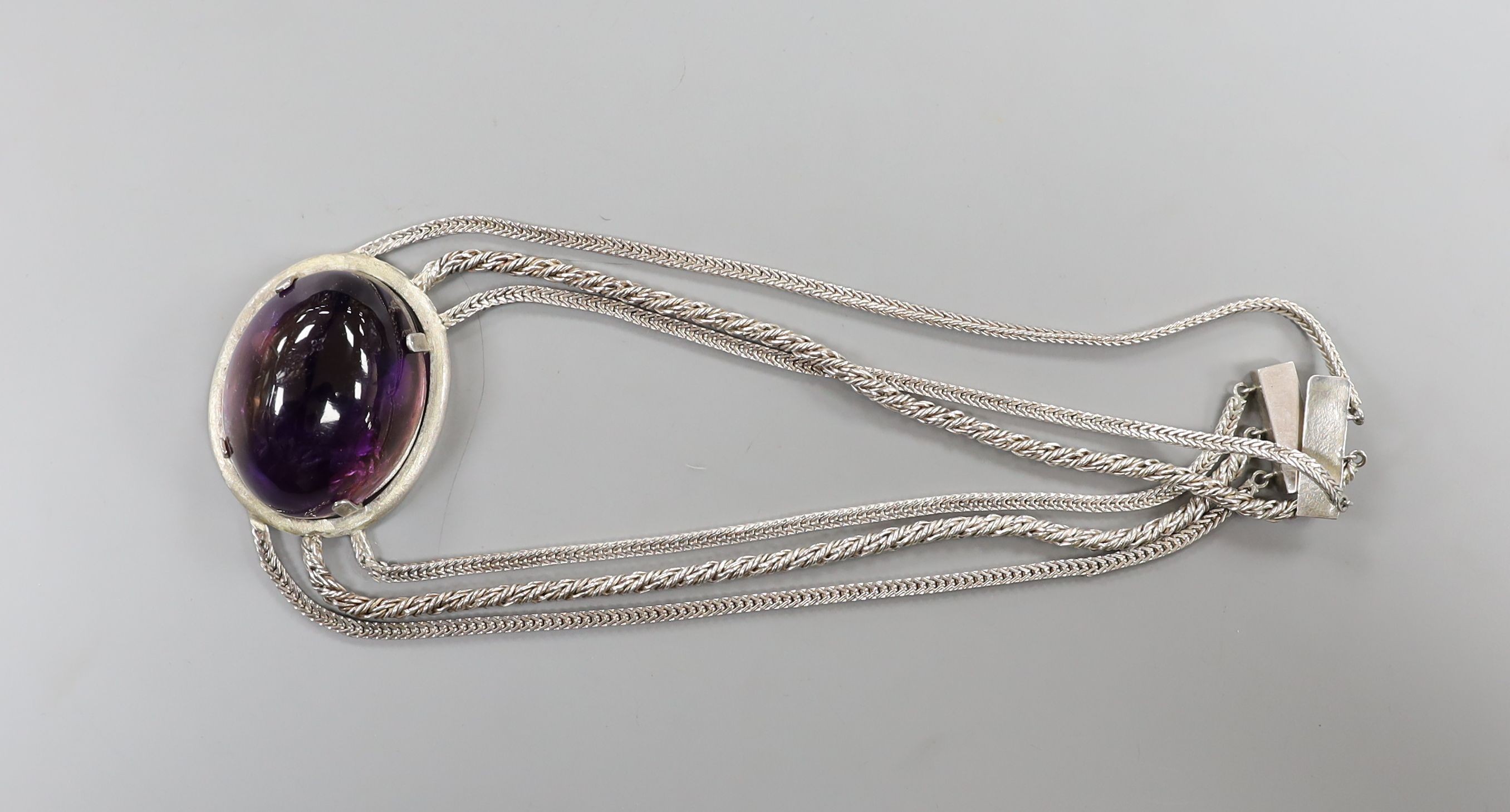 A white metal and large cabochon oval amethyst set triple strand necklace, 47cm